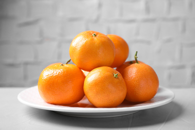 Photo of Fresh ripe juicy tangerines on grey table