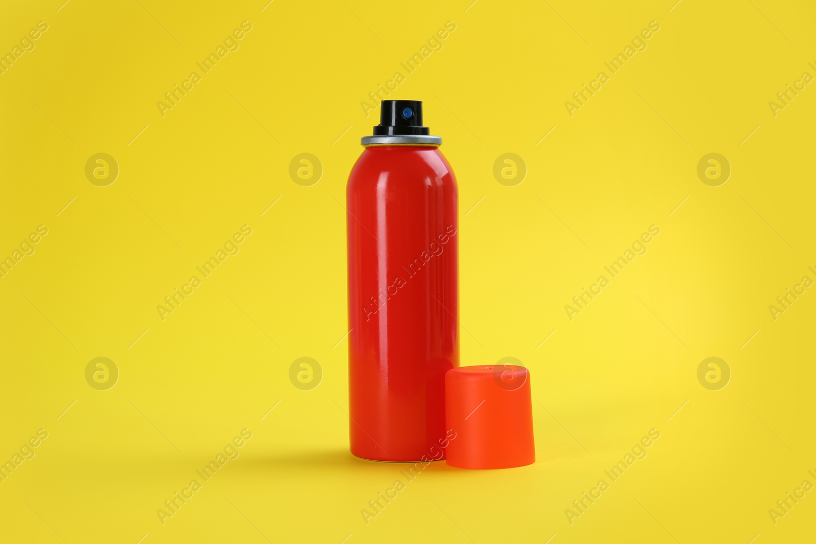 Photo of Bottle with insect repellent spray on yellow background