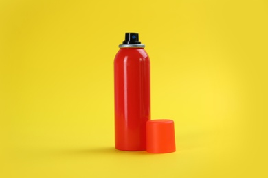 Bottle with insect repellent spray on yellow background