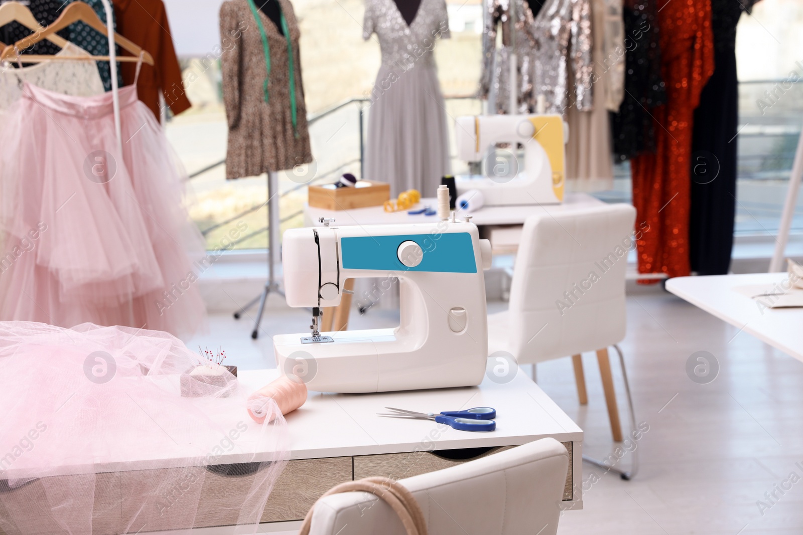 Photo of Sewing machine and equipment on table in dressmaking workshop