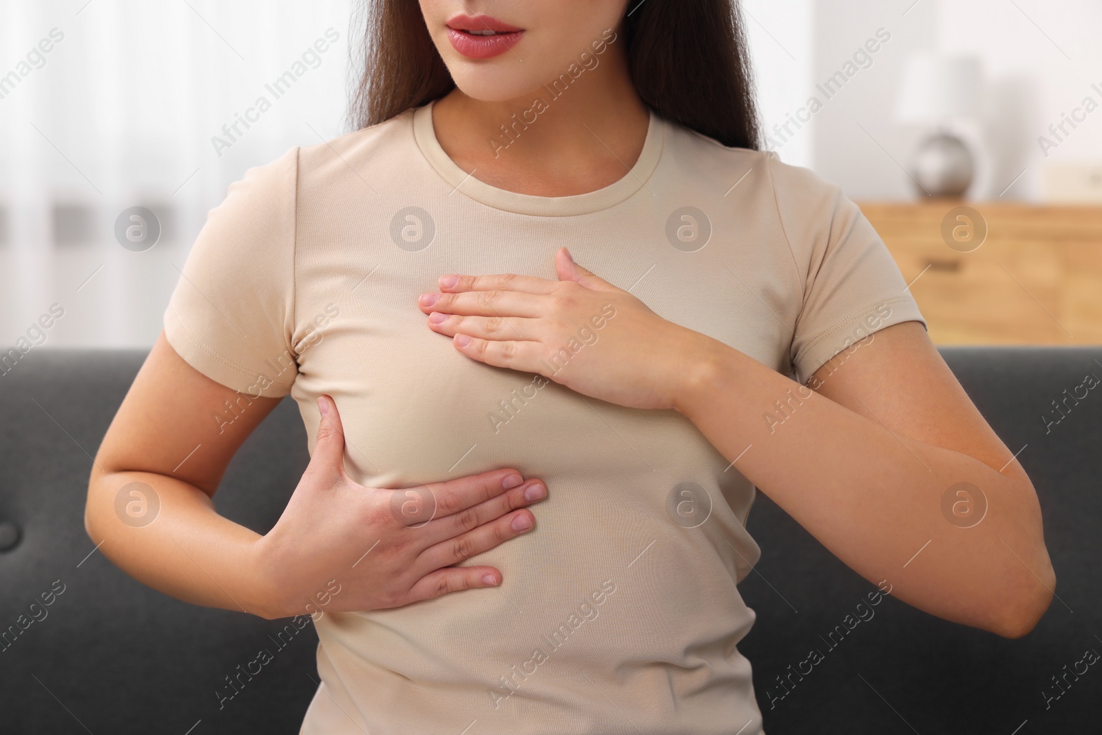 Photo of Woman doing breast self-examination at home, closeup