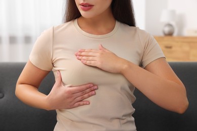 Woman doing breast self-examination at home, closeup