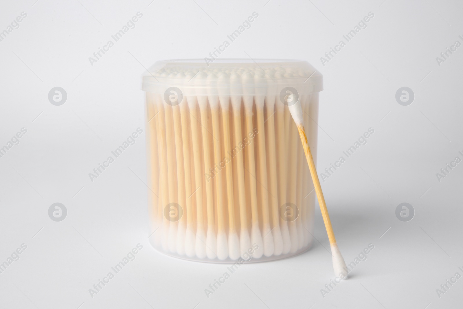 Photo of Many cotton buds in container on white background