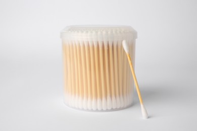 Photo of Many cotton buds in container on white background