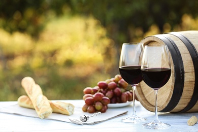 Photo of Composition with barrel of wine and products on table outdoors