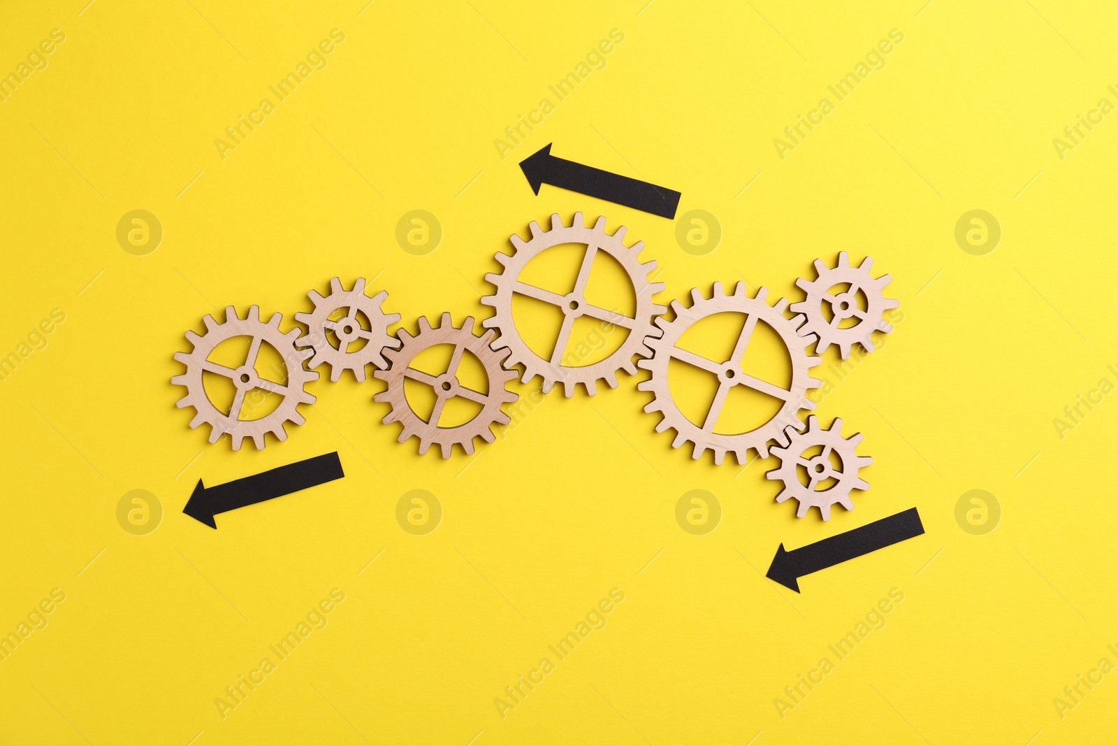 Photo of Business process organization and optimization. Scheme with wooden figures and arrows on yellow background, top view