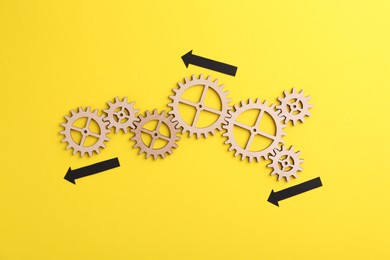 Business process organization and optimization. Scheme with wooden figures and arrows on yellow background, top view