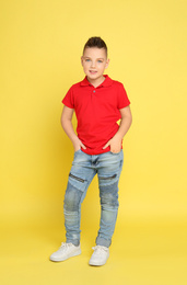 Photo of Full length portrait of cute little boy on yellow background