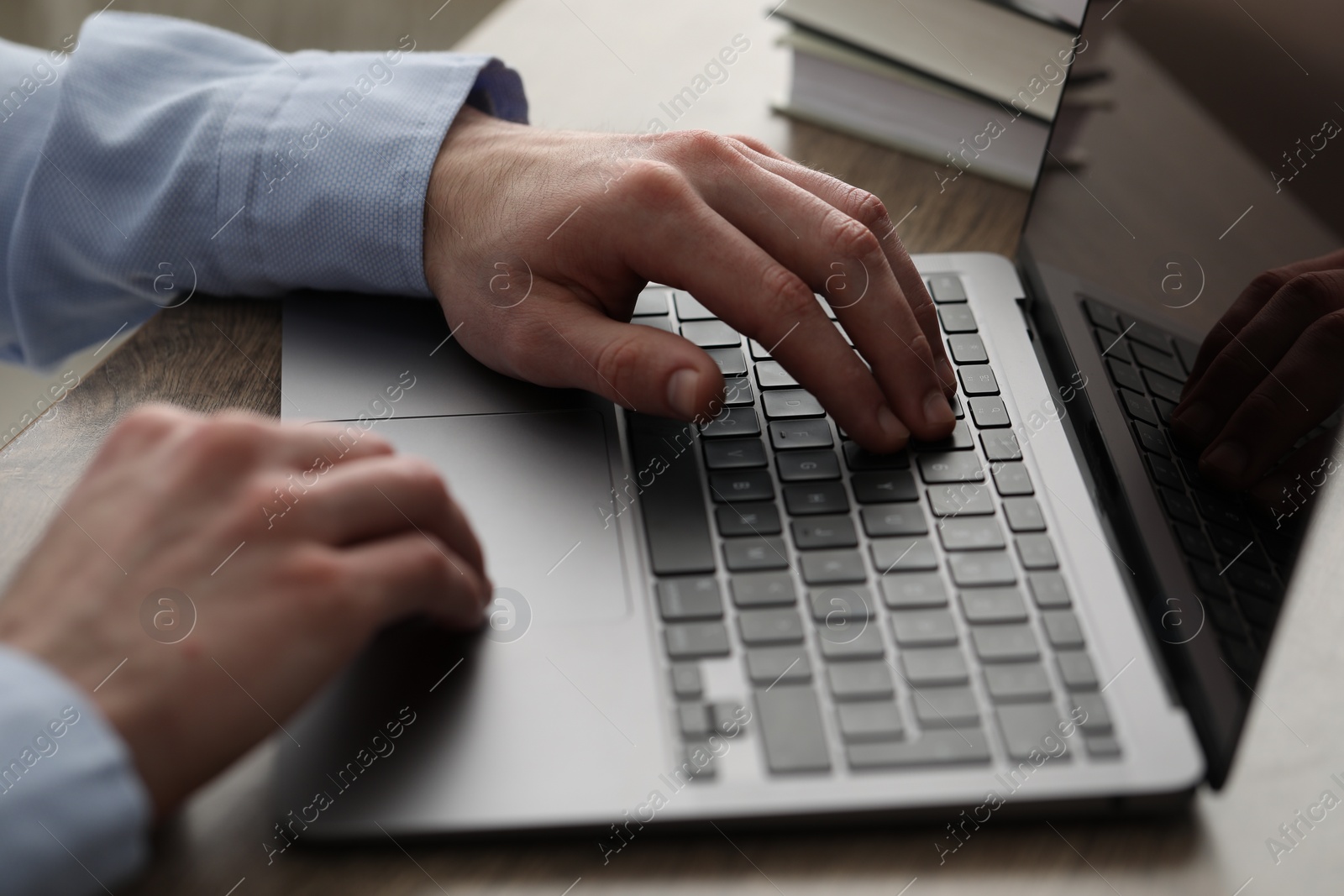 Photo of E-learning. Man using laptop during online lesson at table indoors, closeup