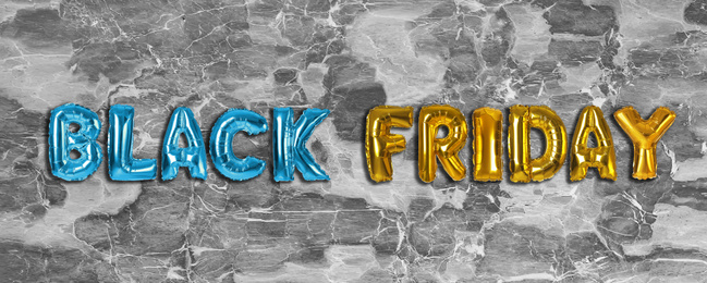 Image of Phrase BLACK FRIDAY made of foil balloon letters on grey stone background. Banner design