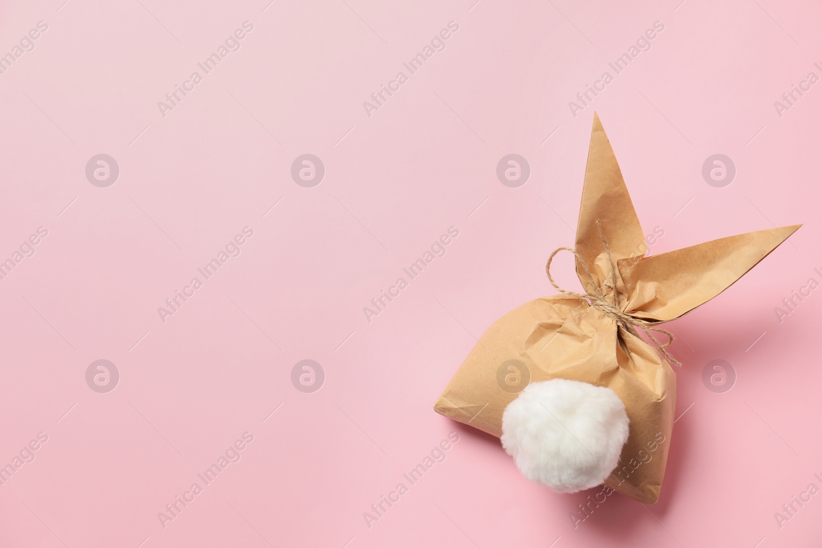 Photo of Creative Easter bunny gift bag on color background, top view with space for text