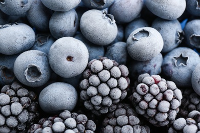 Photo of Tasty frozen blackberries and blueberries as background, top view