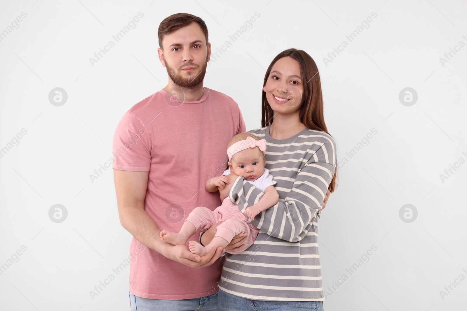Photo of Happy family. Parents with their cute baby on light background