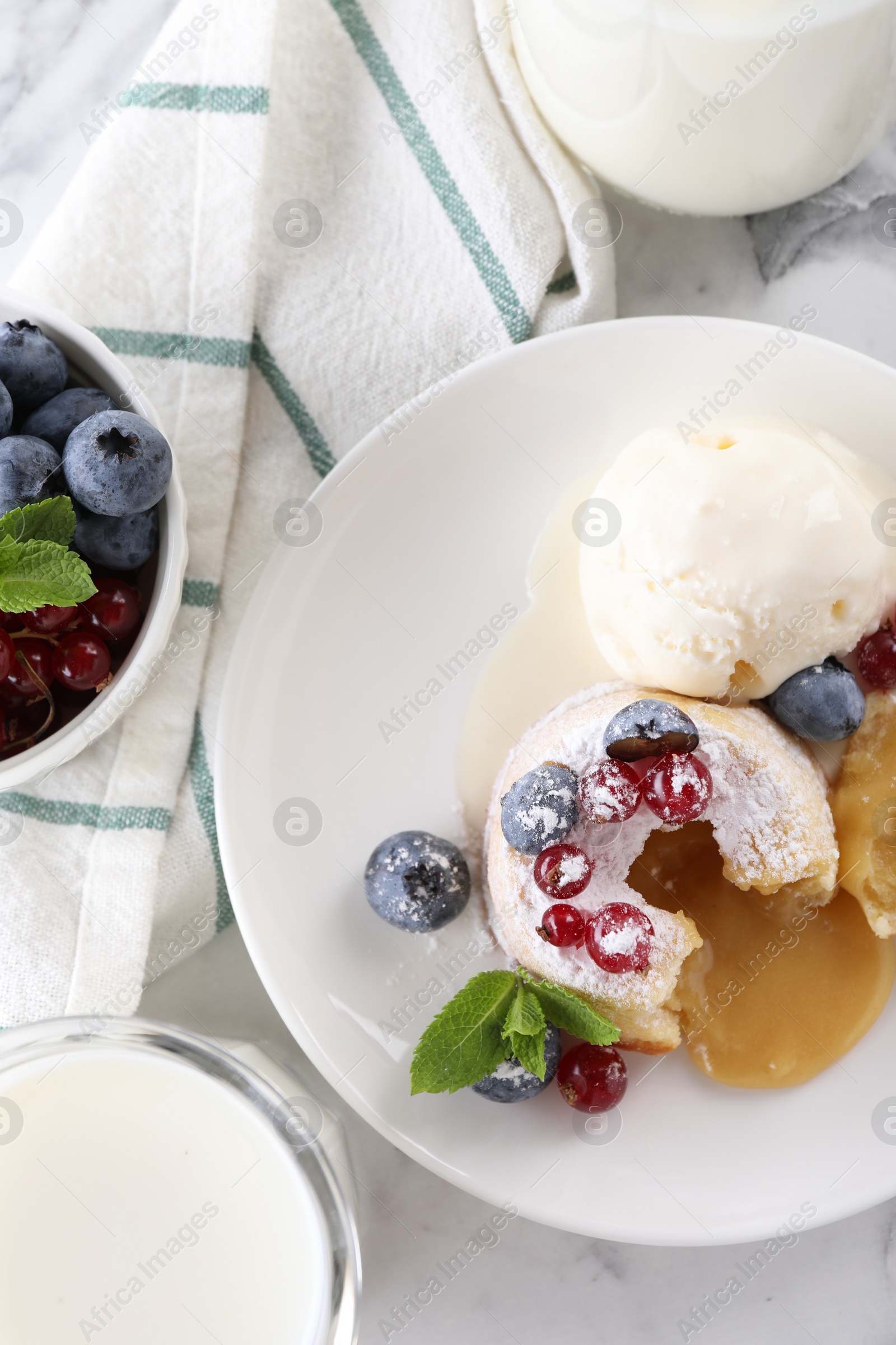 Photo of Tasty vanilla fondant with white chocolate, berries and ice cream served on white table, flat lay