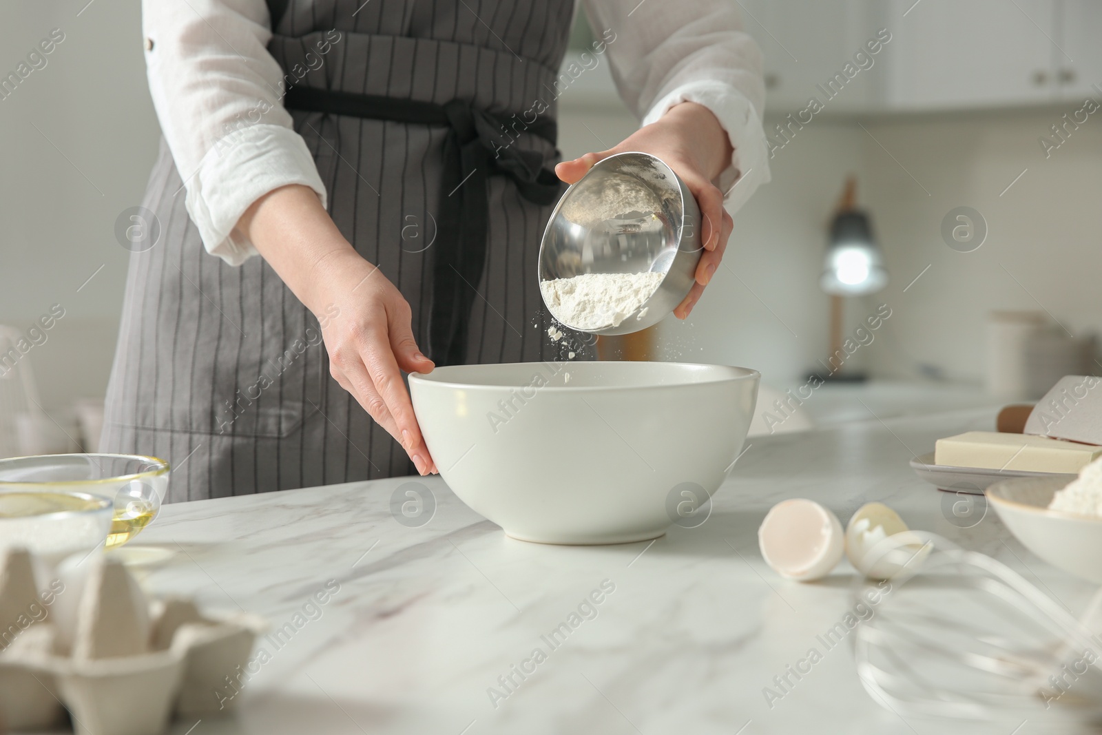 Photo of Woman making dough at table in kitchen, closeup