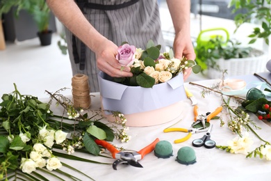 Photo of Male florist creating floral composition at workplace