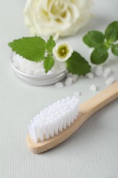 Photo of Toothbrush, salt and herbs on white background, closeup