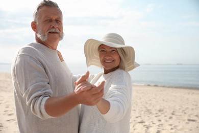 Photo of Mature couple spending time together on sea beach