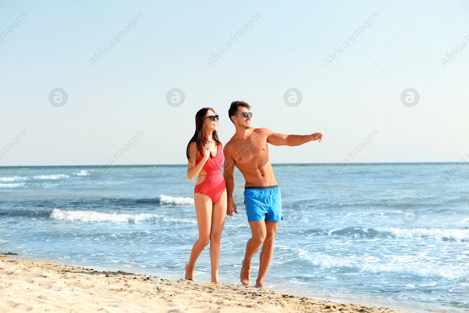 Photo of Happy young couple walking together on beach