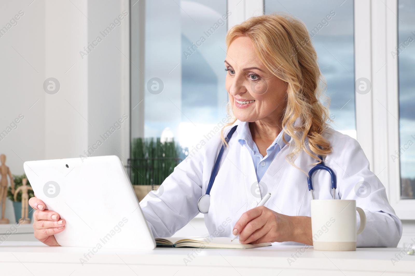 Photo of Doctor with tablet consulting patient in clinic. Online medicine concept