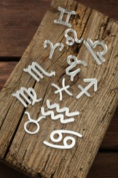 Photo of Zodiac signs on wooden table, above view