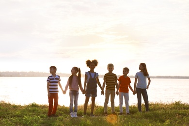 Photo of Cute little children playing together outdoors on sunny day