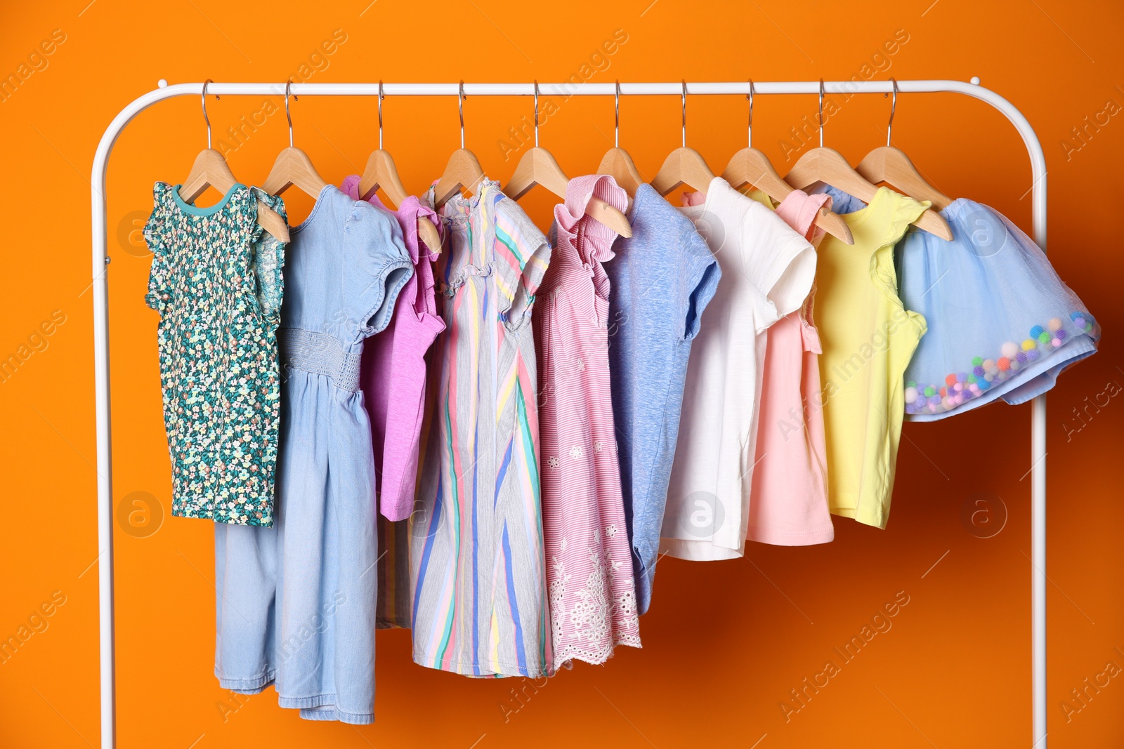 Photo of Rack with stylish child clothes on color background