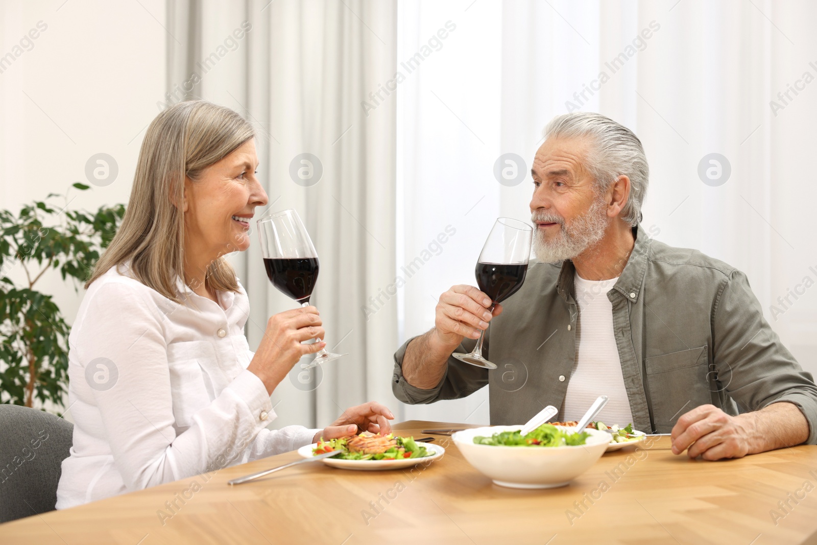 Photo of Happy senior couple having romantic dinner at home