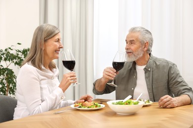 Happy senior couple having romantic dinner at home