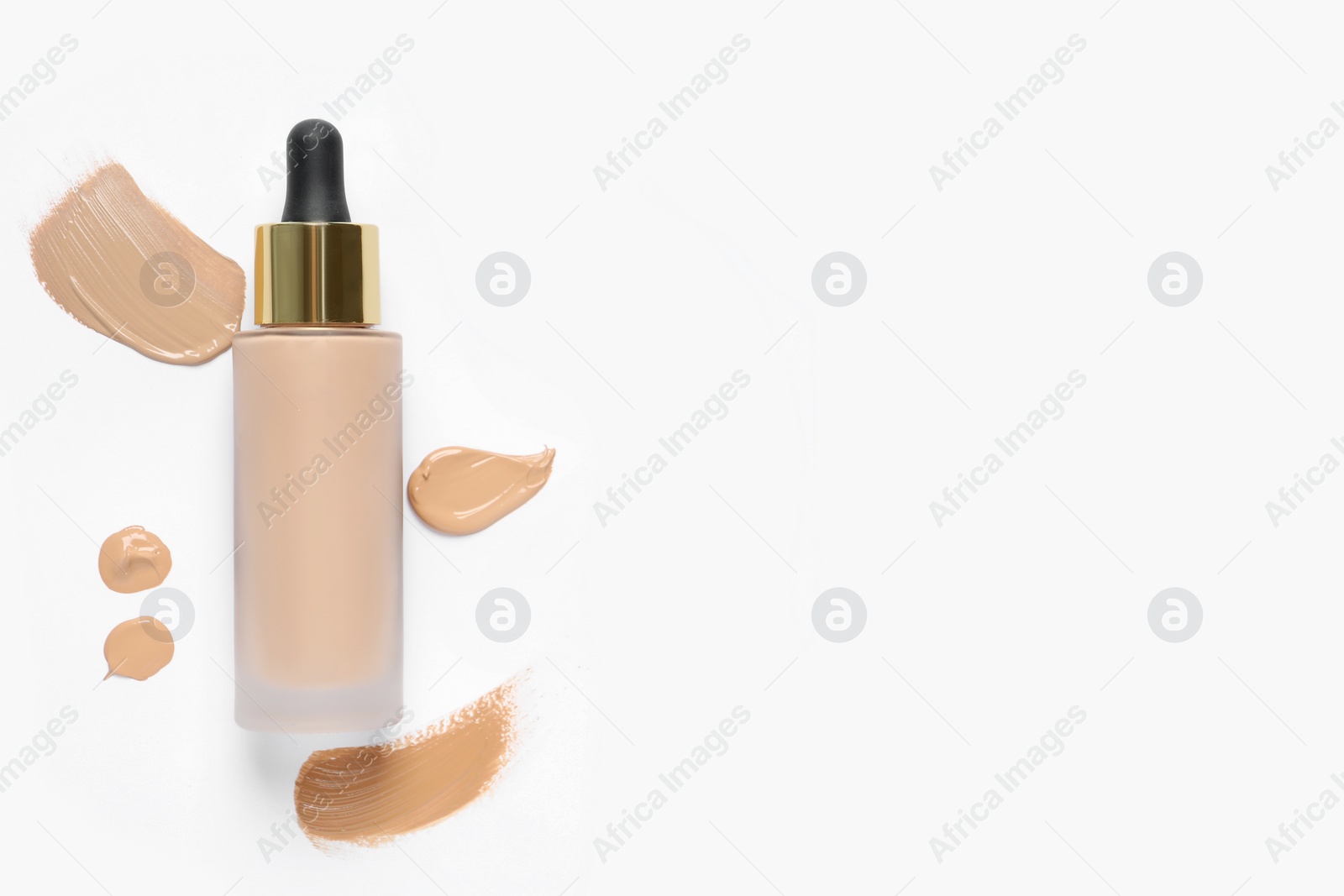 Photo of Liquid foundation and swatches on white background, top view. Space for text