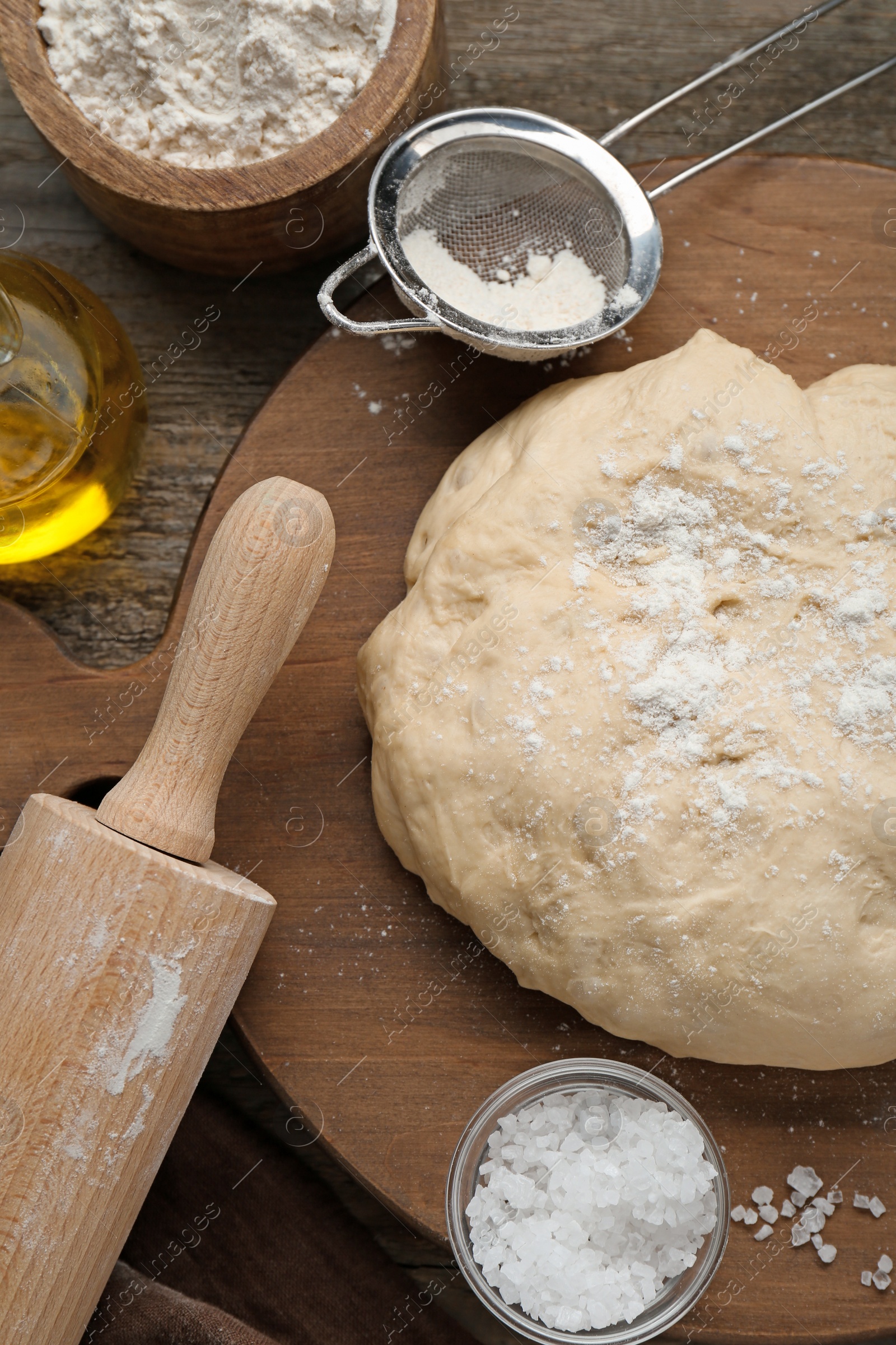 Photo of Fresh yeast dough and ingredients on wooden table, flat lay