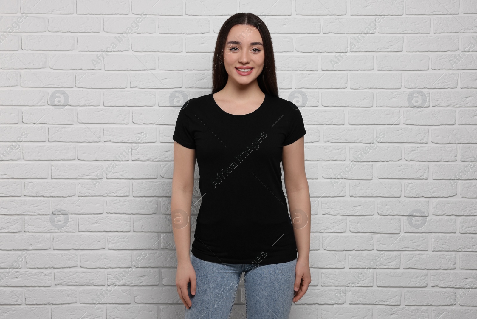 Photo of Woman wearing stylish black T-shirt near white brick wall