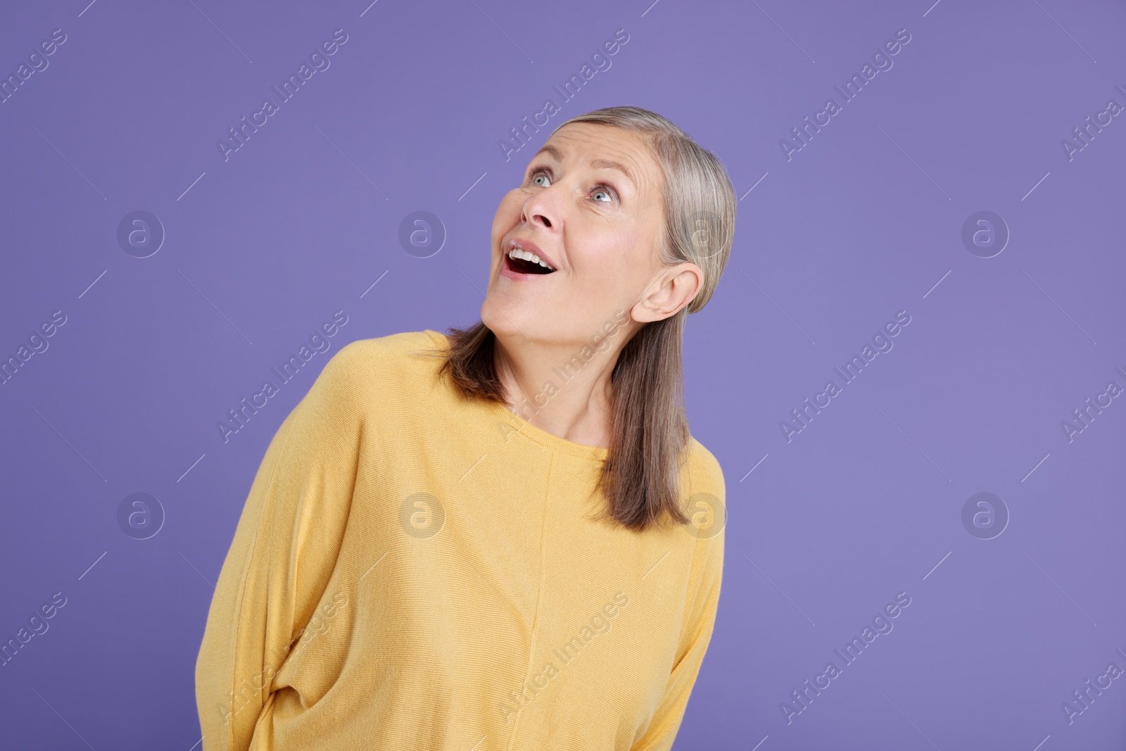 Photo of Portrait of surprised senior woman on violet background