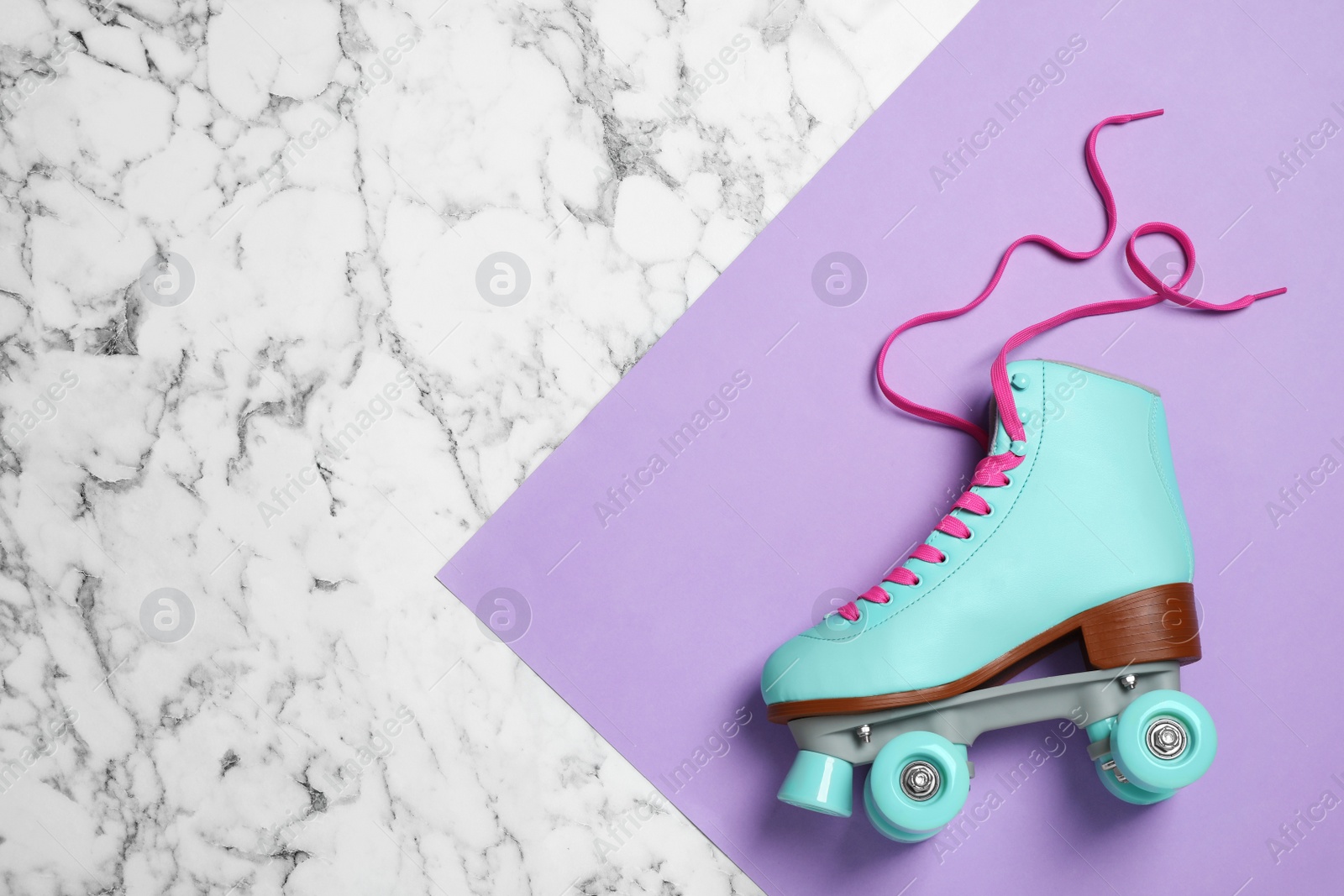 Photo of Stylish quad roller skate on color background, top view