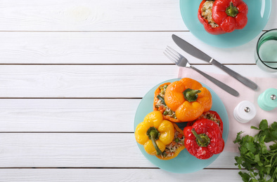 Photo of Tasty stuffed bell peppers served on white wooden table, space for text