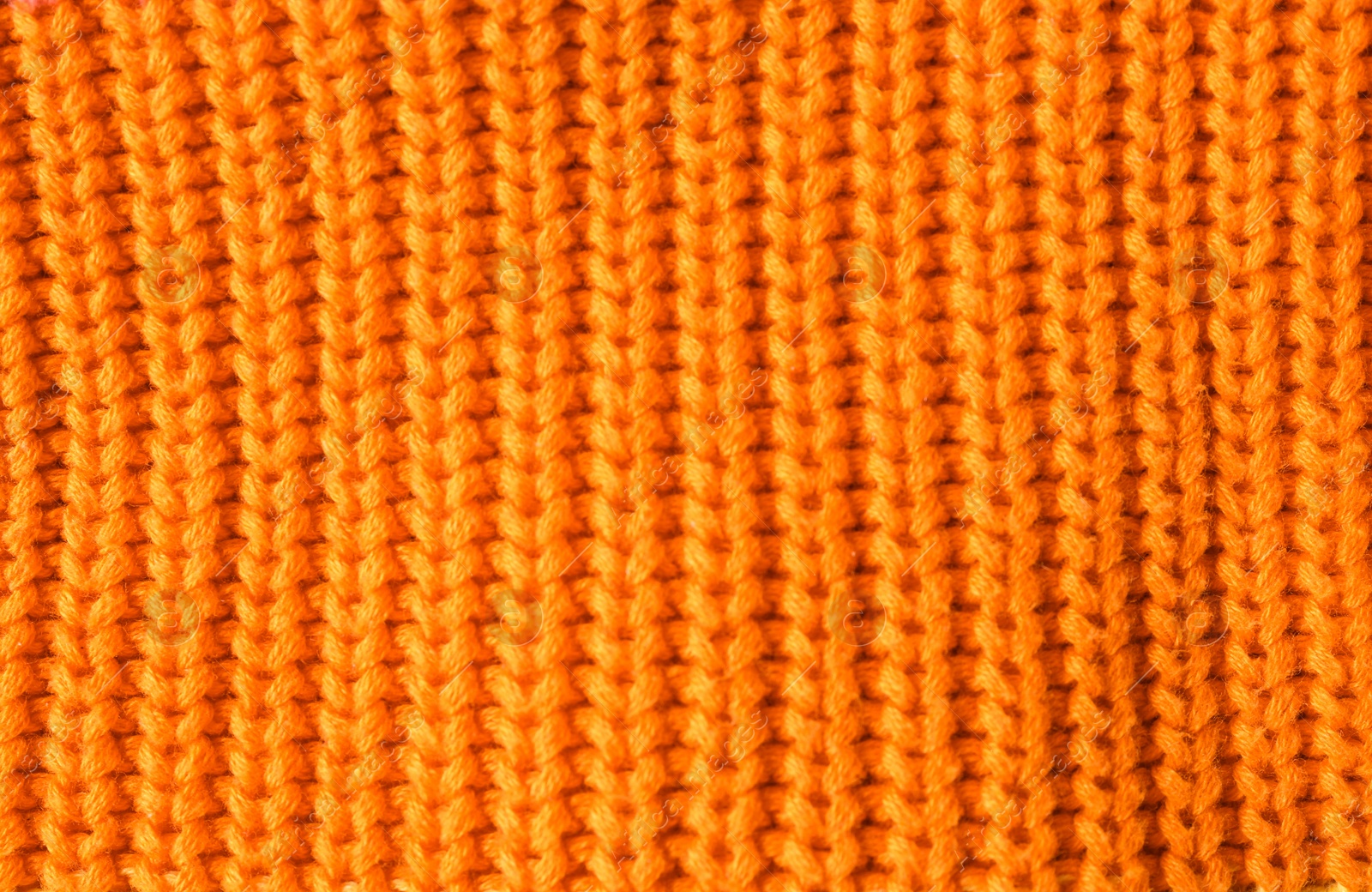 Photo of Texture of knitted orange fabric as background, closeup