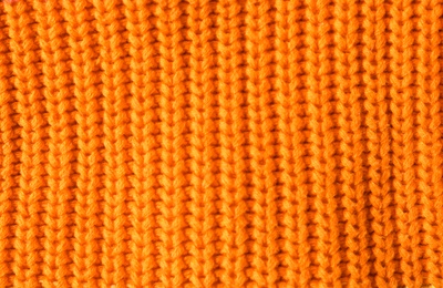 Photo of Texture of knitted orange fabric as background, closeup