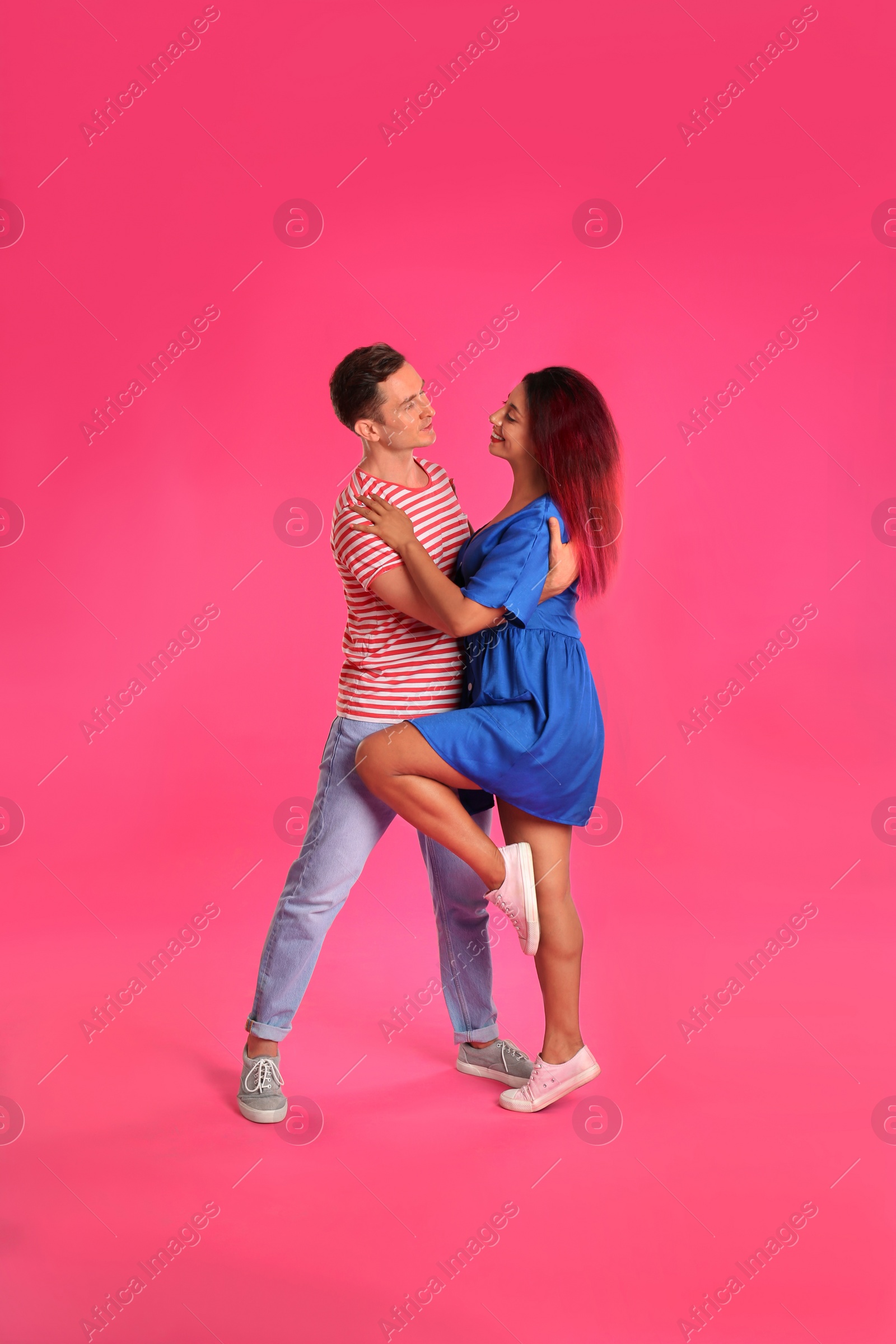 Photo of Beautiful lovely couple dancing on pink background