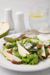 Photo of Delicious pear salad on white tiled table, closeup