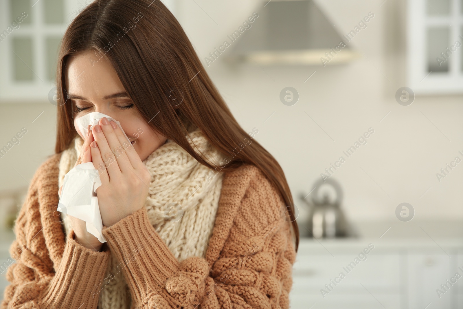 Photo of Sick young woman sneezing at home. Influenza virus