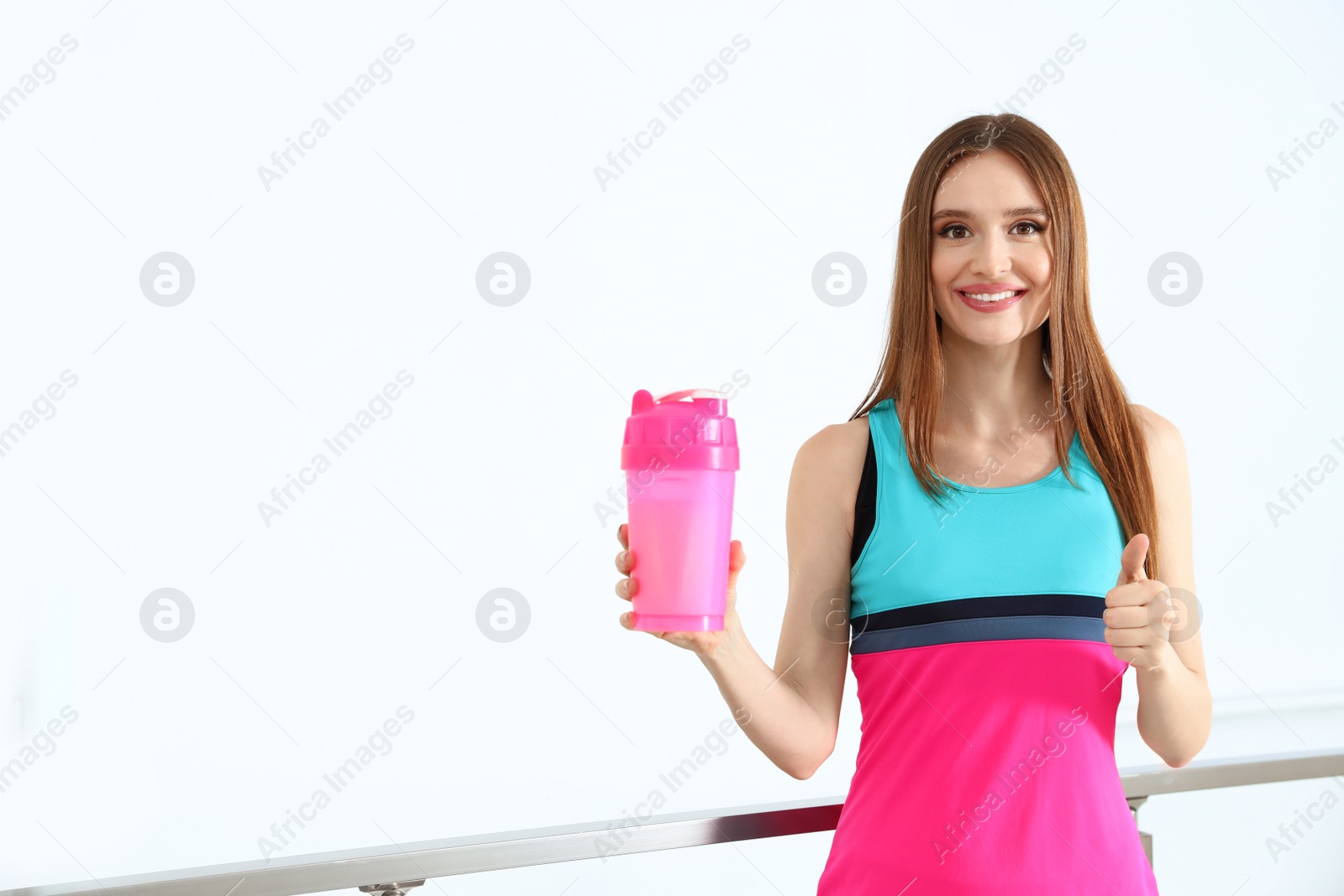 Photo of Young woman with protein shake indoors. Space for text