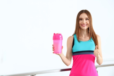 Photo of Young woman with protein shake indoors. Space for text