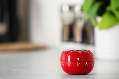 Photo of Kitchen timer in shape of tomato on white table indoors. Space for text