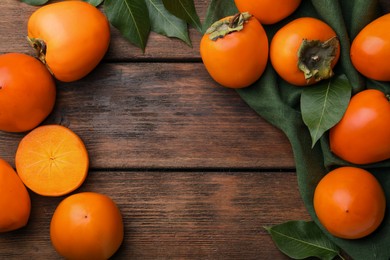 Photo of Delicious ripe persimmons on wooden table, flat lay. Space for text