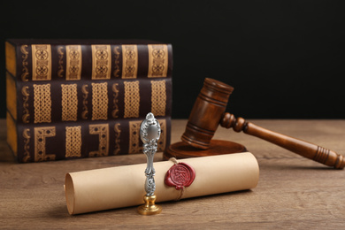 Notary's public pen, sealed document and gavel on wooden table