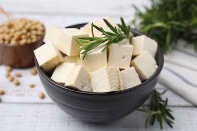 Photo of Delicious tofu cheese, rosemary and soybeans on white wooden table, closeup
