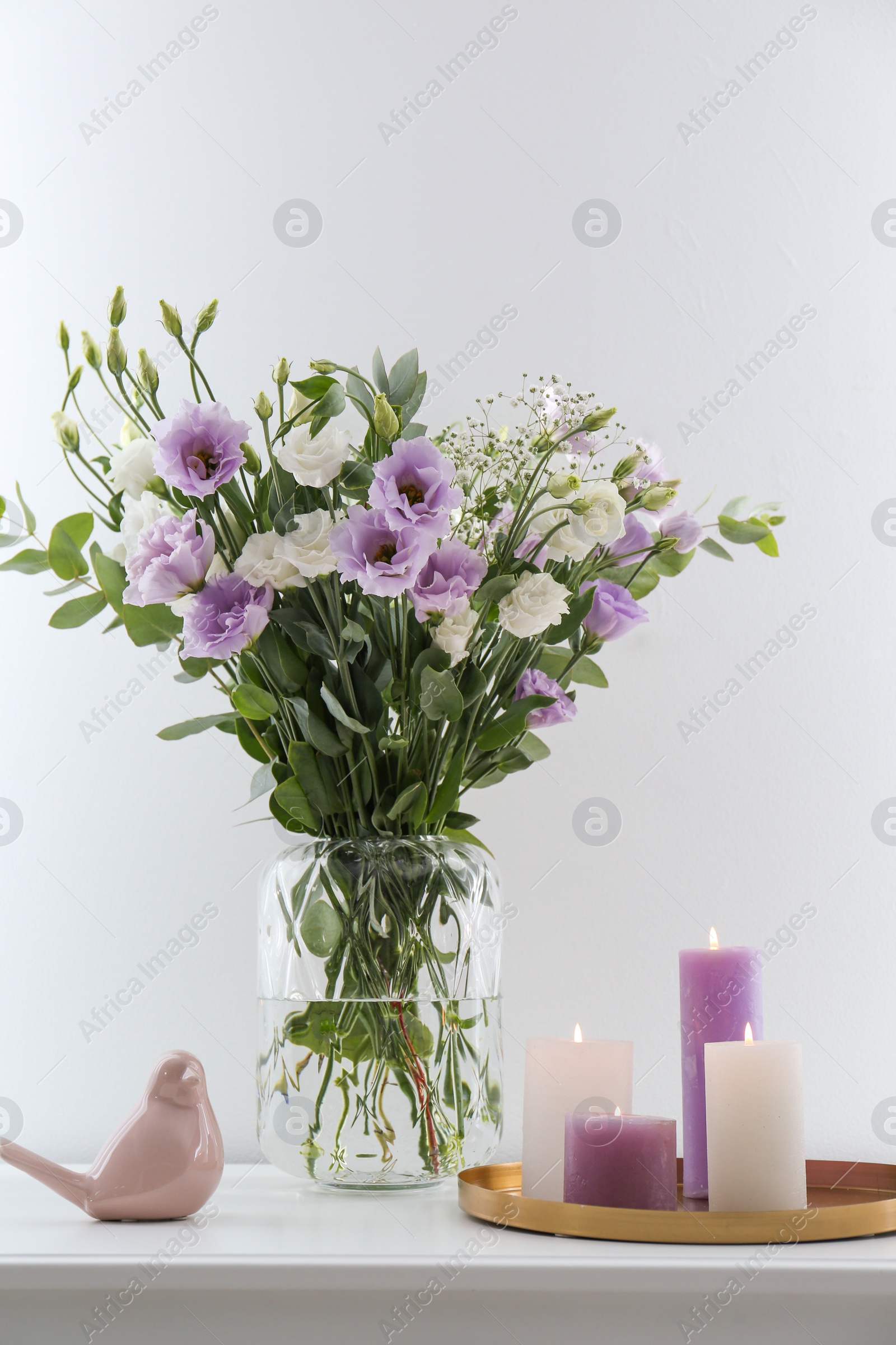 Photo of Bouquet of beautiful Eustoma flowers on white table