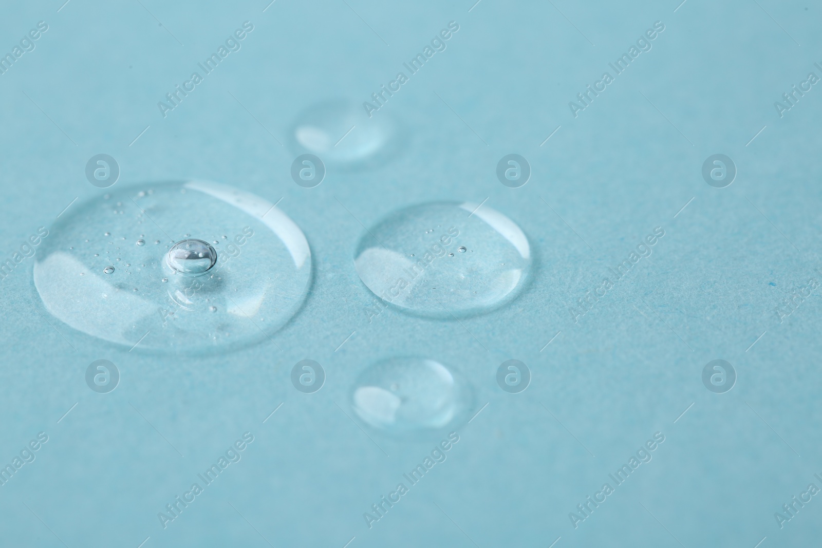 Photo of Samples of cosmetic serum on light blue background, closeup. Space for text