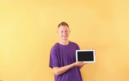 Photo of Portrait of handsome man with tablet on color background