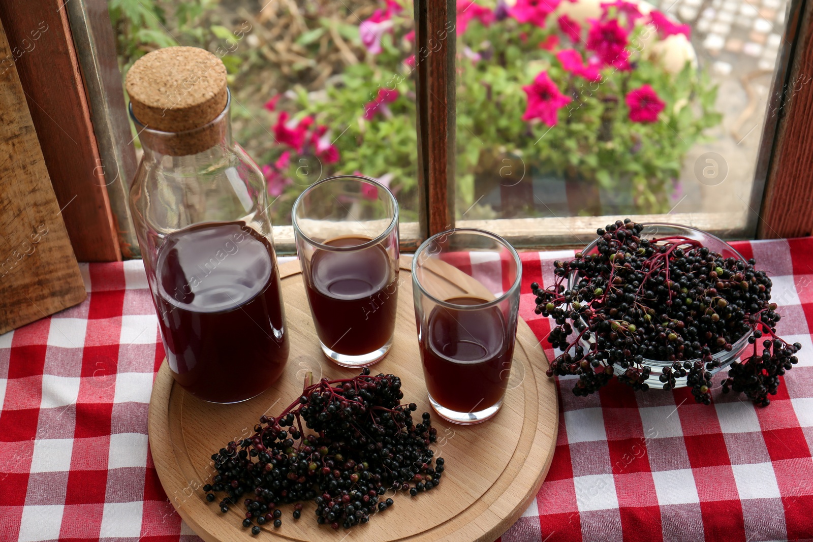 Photo of Elderberry drink and Sambucus berries on table near window